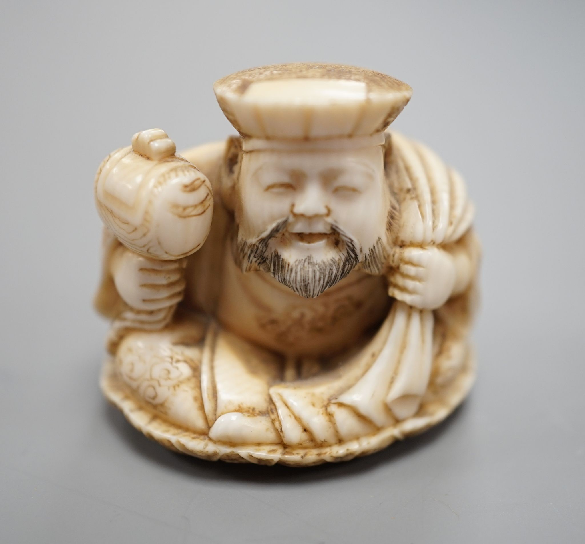 A Japanese ivory netsuke of Daikoku, Meiji period, 3 cms high.